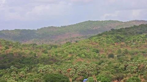 Moving Clouds creating beautiful shadows on a mountain with houses Video stock 157380656