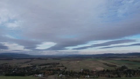 Moving clouds during sunset, mountains area, farmfield Stock Footage 257788917
