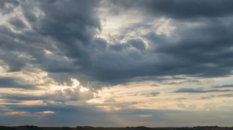 Moving clouds over field an sunset, with solar rays. Time lapse. Stock Footage 47981188