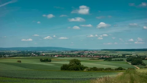 Moving clouds over a wheat field over the hillsape of the Wetterau Видео 90368148