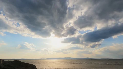 Moving clouds in the rays of the bright sun at sunset. Time lapse. Video stock 238527033