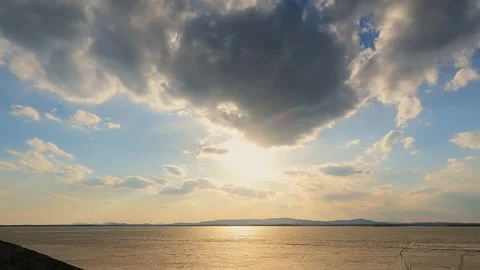 Moving clouds in the rays of the bright sun at sunset. Time lapse. Stock Footage 238527101