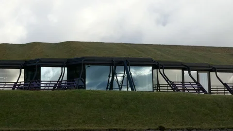 Moving clouds reflection on the windows of a Nordic house with grass roof Stock Footage 92640226