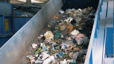 Moving conveyor at a garbage plant, close up. Trash goes on a conveyor after Vidéo 93335484