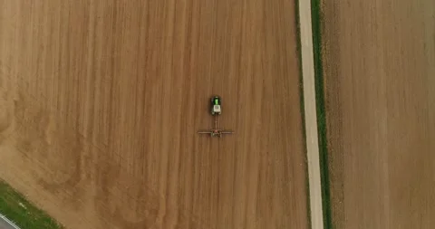 Moving copter down. The top view of the tractor working on the harvest field in Stock Footage 205443122