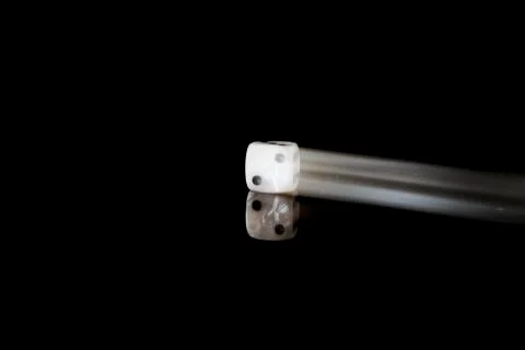 Moving die on a reflective surface with black background Stock Photos