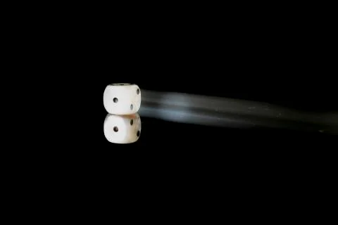 Moving die on a reflective surface with black background Stock Photos