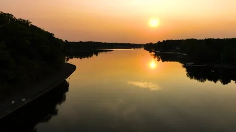 Moving down and forward over the placid waters of Mona Lake during a Vídeo Stock 242318633
