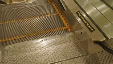 Moving down escalator steps with a social distancing sign in a modern mall Video stock 343418744