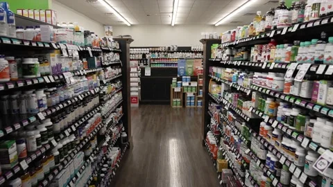 Moving down a store aisle with supplements and vitamins in a health foods market Stock Footage