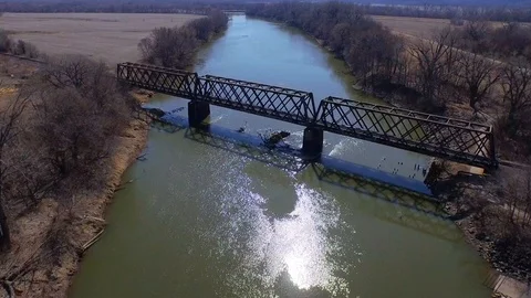 Moving downstream tilting down over railway bridge Stock Footage 90258960