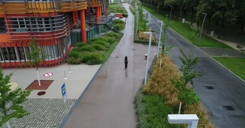 Moving up drone. The back view at the beautiful woman walking along the modern Stock Footage 82242133