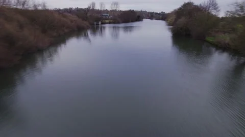 Moving drone shot over river and lake past lakeside houses and trees Stock Footage 167769634