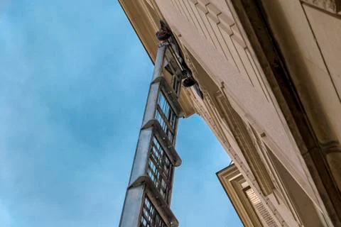 Moving elevator with ladder on the fifth floor in the city. Stock Photos