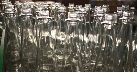 Moving empty glass bottles on a conveyor belt at an industrial bottling plant Stock Footage 303107686