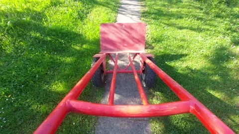 Moving empty red hand truck on garden path first person view Stock Footage 334328454