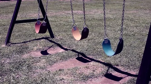 Moving empty swings in park, dark gloomy terror concept 库存影片 107169723