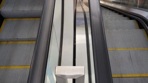 Moving escalator belts going up and down in a department store, airport, or trai Stock Footage 315543582