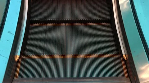 Moving escalator steps ascending with side panels and visible safety brushes. Stock Footage 314677858