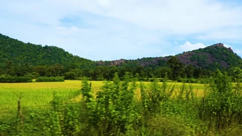 Moving farm scene from vehicle, featuring majestic mountains and a stunning sky Stock Footage 321861724