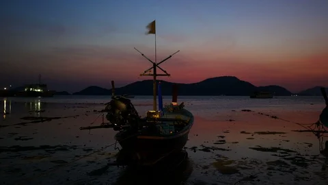 Moving  flag on long tail boat park on sea beach with low tide sea and silhou Stock Footage 99008038