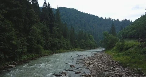 Moving forward above a river in a forest mountain valley. Low flight aerial shot Stock Footage 127048745