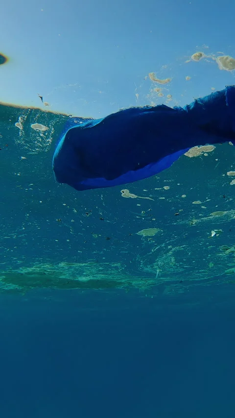 Moving forward below plastic and other waste floats on water surface Stock Footage 332309086