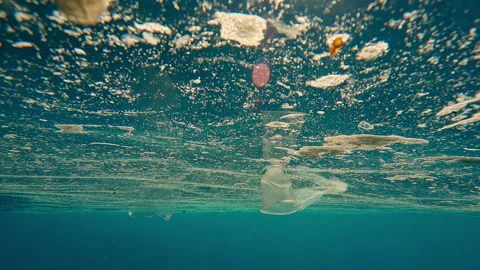 Moving forward close to large oily slick of plastic waste drifting on surface of Stock Footage 339970077