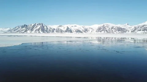 Moving forward over water with mountains in the horizon and a clear blue sky Stock Footage 95213802