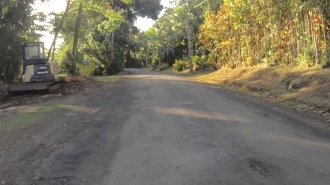 Moving forward riding view at a backroad in tropical Pacific Islands where const Stock Footage 235311053