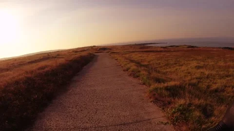Moving forward scooter riding view   on road of dry deserted grass bush land at  Stock Footage 240483241