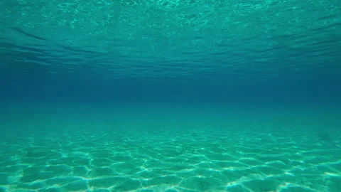 Moving forward in turquoise water over andy seabed with sun glinting on sand Видео 331107628