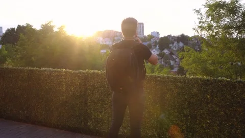 Moving frame from behind a tourist at sunset. Tourist with a backpack who Stock Footage 140286490