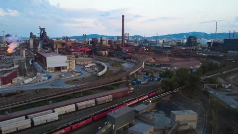 Moving freight train at a steelworks with glowing slag in the background Video stock 342939486