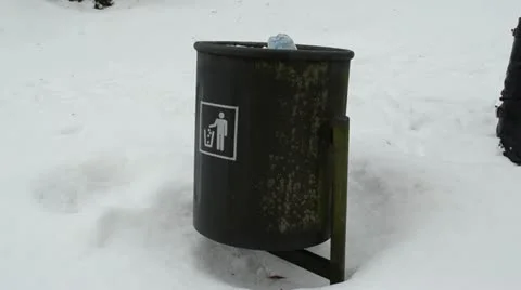 Moving full garbage dustbin waste bin snow winter park Stock Footage 20489254