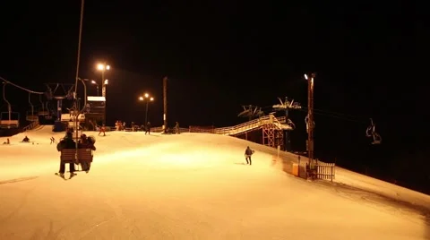 Moving funicular at night and track with many skiers in ski resort Video stock 63030262