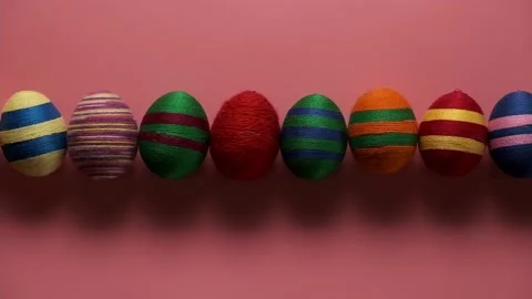 Moving group of colorful easter egg made from threads isolated on pink Video stock 166779675