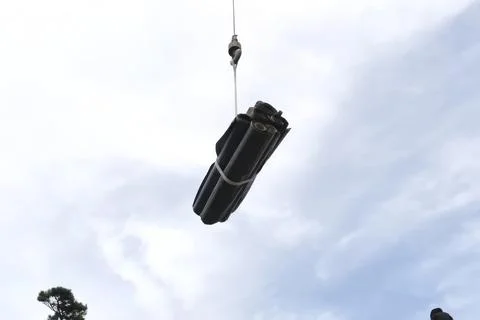 Moving to a height using a rope and lift, a roll of waterproofing roofing r.. Stock Photos