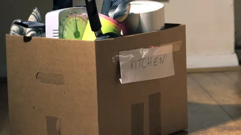 Moving home with kitchen goods packed in a box Stock Footage 252750857