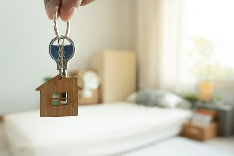 Moving house, relocation. Man hold key house keychain in new apartment, ins.. Stock-Fotos