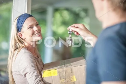 Moving House: Woman Carrying Cardboard Box, Man Holding House Keys