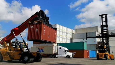 Moving lifted loaded container in a container yard using the Reach Stacker Stock Footage 120357768