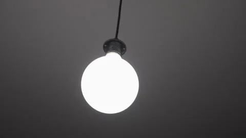 Moving light bulb attached to a cord Stock Footage 322122935