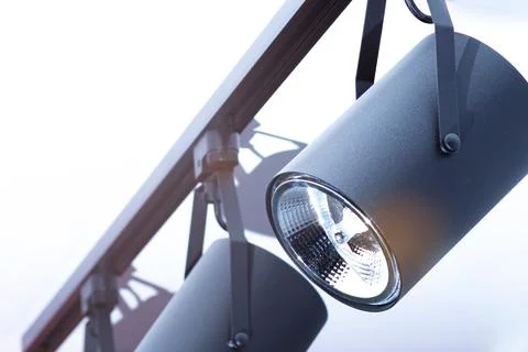 Moving light fixed on the ceiling in the form of a group of black lamps Stock Photos