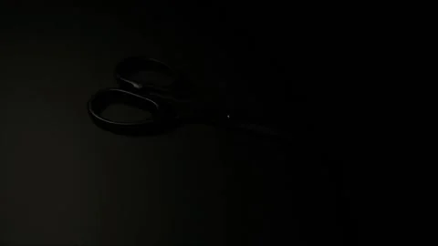 Moving light that illuminates metal scissors in the dark. Stock Footage 152601499