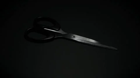 Moving light that illuminates metal scissors in the dark. Stock Footage 152601501