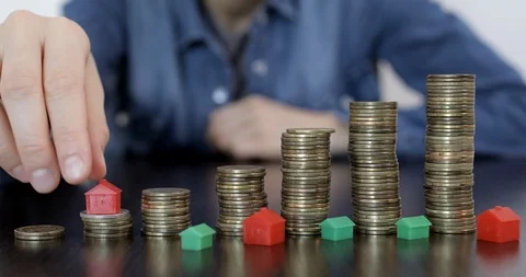 Moving mini model of house on piles of coins. Stock Footage 122300609