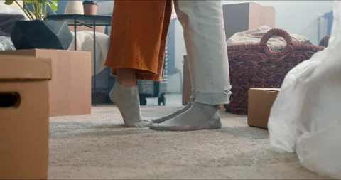 MOVING INTO NEW HOME CONCEPT. Close-up legs of young man and woman celebrating Video stock 158083268