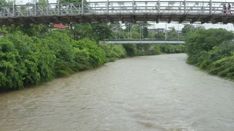 Moving over a large river with a brown coloration under a old bridge Vidéo 146351666
