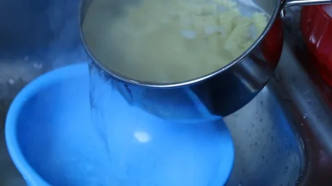 Moving pasta from pan to colander Stock Footage 93149366
